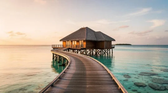Bungalow sur pilotis face à un lagon turquoise des Maldives au lever du soleil
